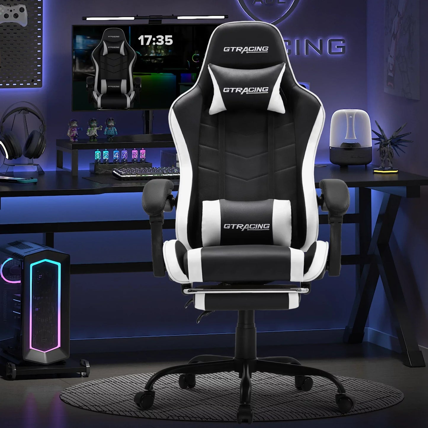 Black and white GT Racing ergonomic gaming chair in a modern blue-lit gaming setup with monitor and PC