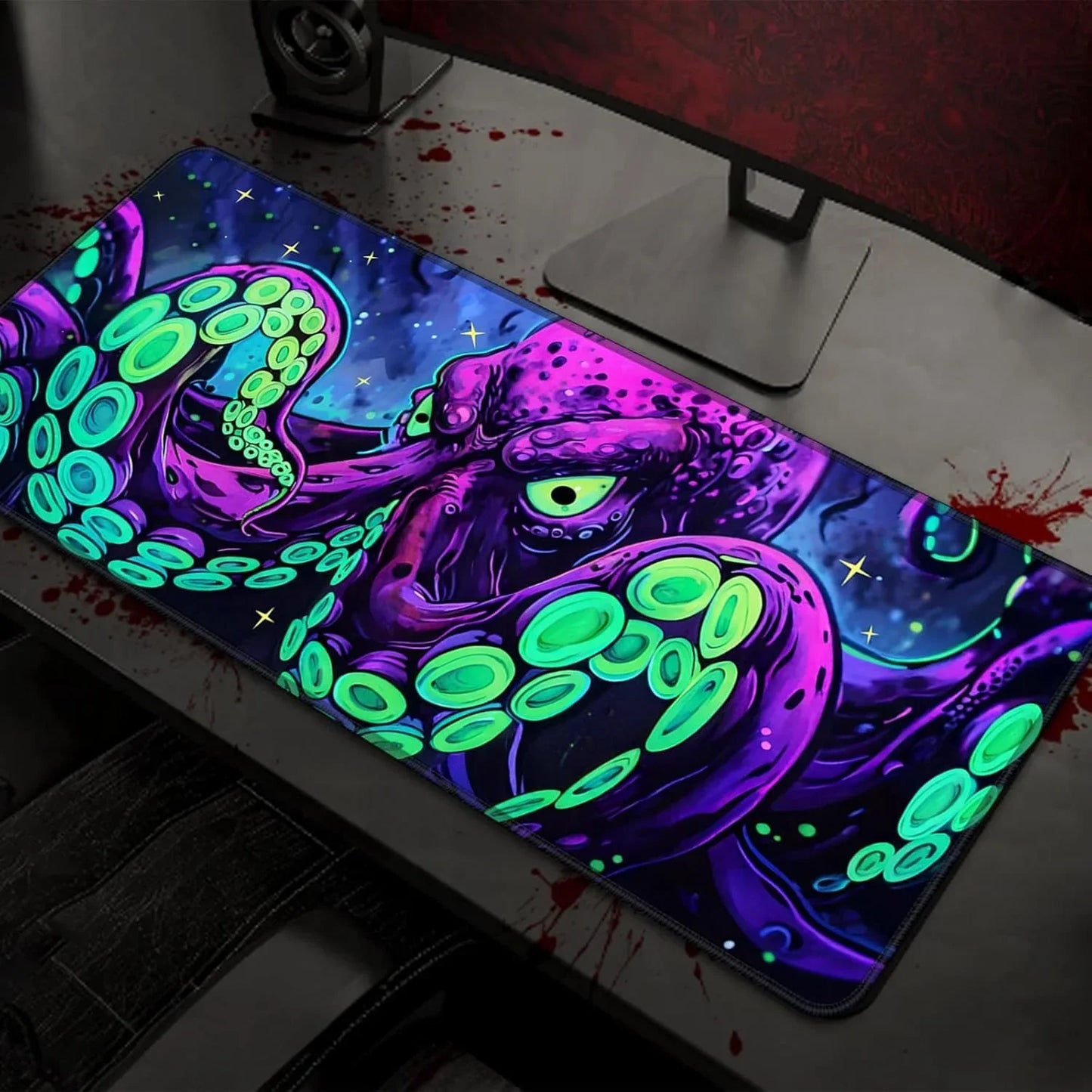 Gaming desk setup with colorful octopus-themed RGB mouse pad under a monitor stand