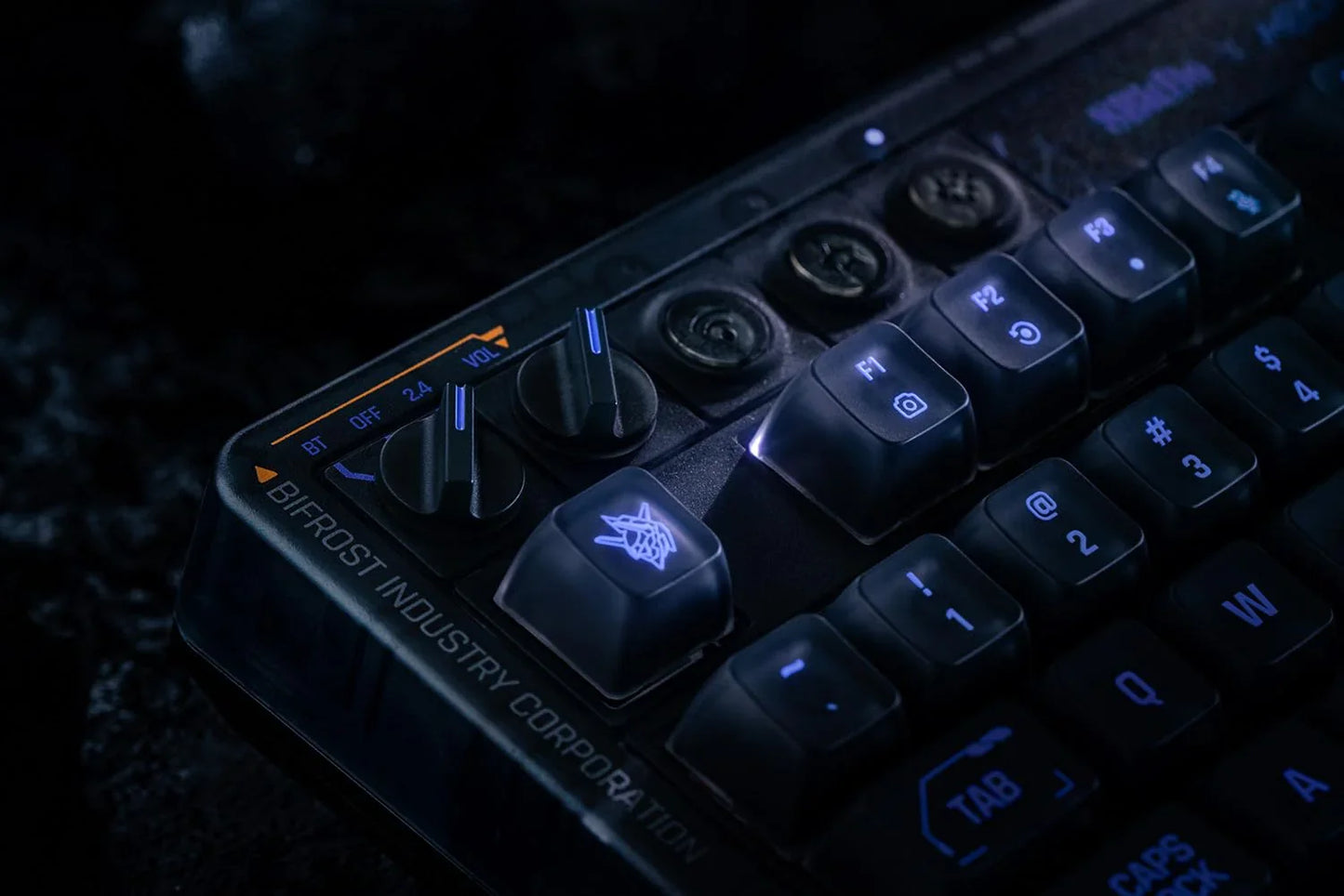 Close-up of a retro gaming keyboard with illuminated keys and volume knobs