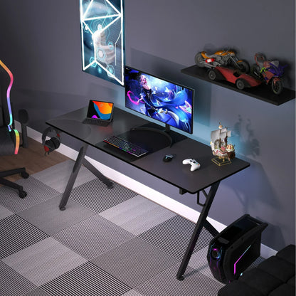 Modern gaming desk setup with curved monitor, RGB keyboard, tablet, gaming chair, and PC tower