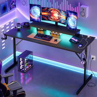 Modern gaming desk setup with triple monitors, RGB keyboard, gaming PC, neon LED lights, and black chair