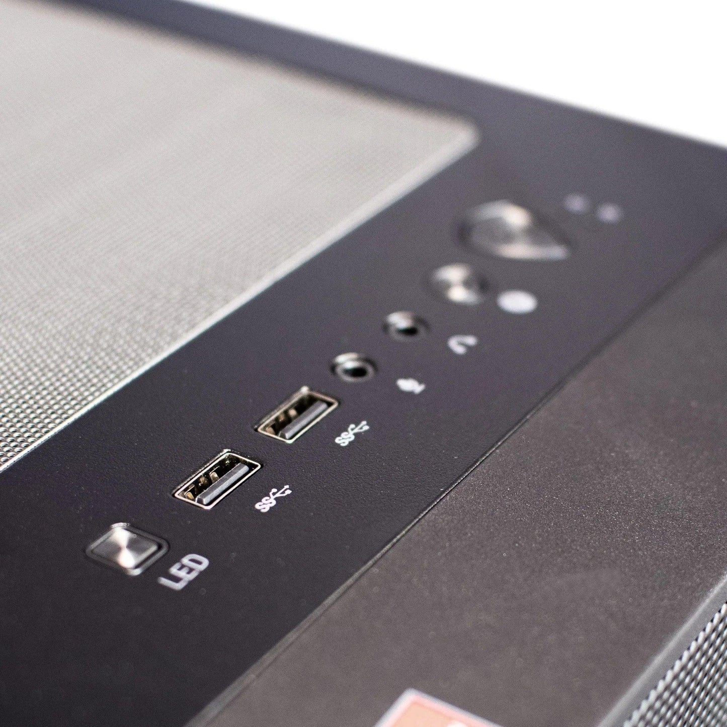 Close-up of a gaming PC case front panel with USB ports, audio jacks, and LED button