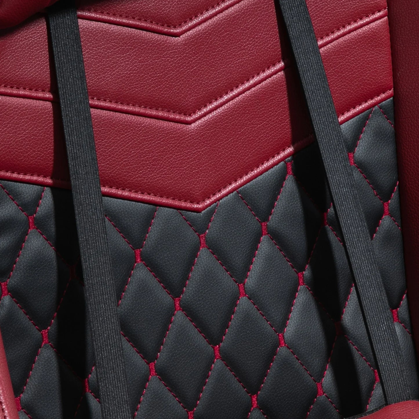 Close-up of red and black quilted leather gaming chair upholstery with black straps