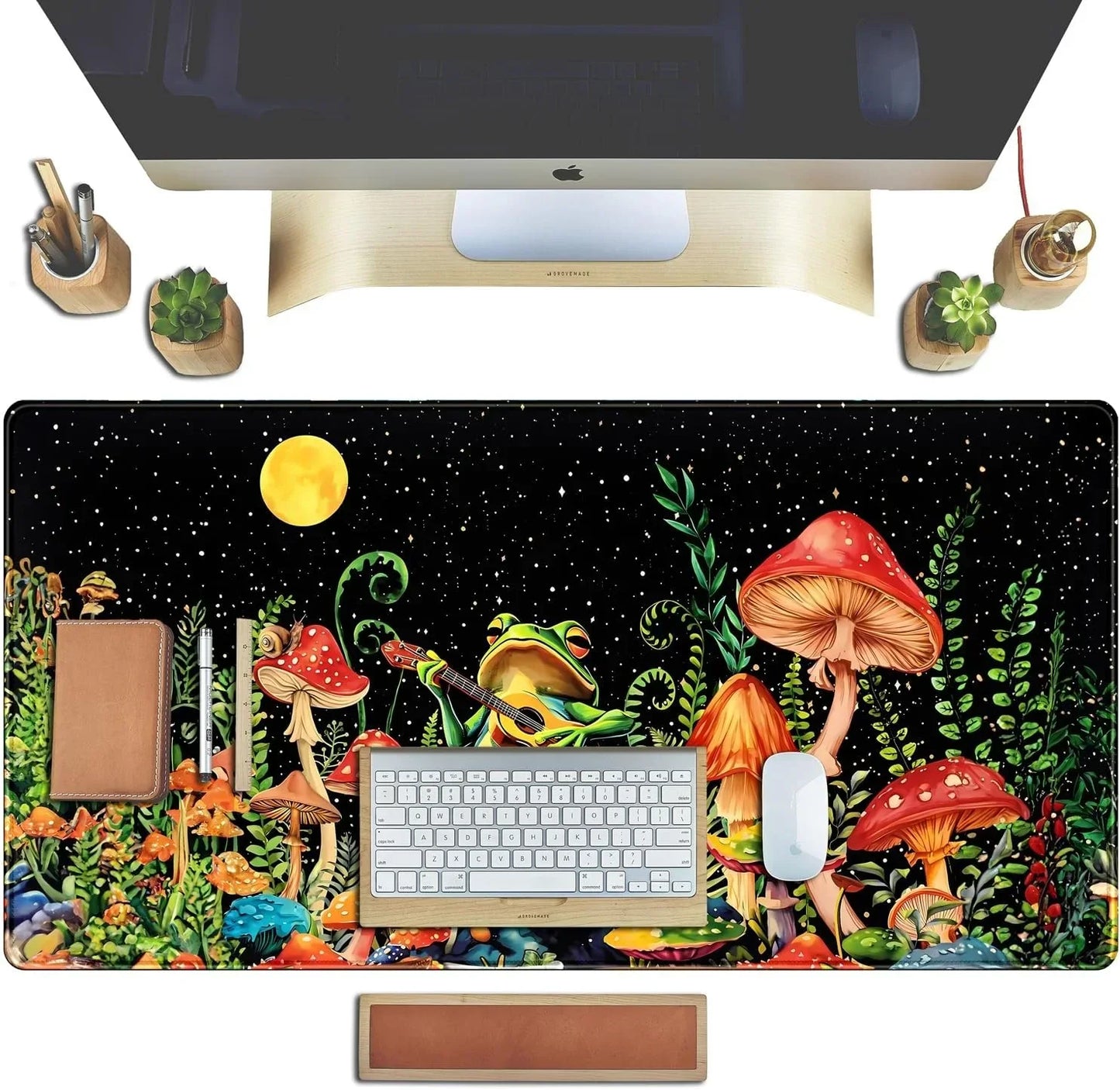 Desk setup with colorful mushroom and frog guitar art mousepad, keyboard, mouse, plants, and wooden accessories