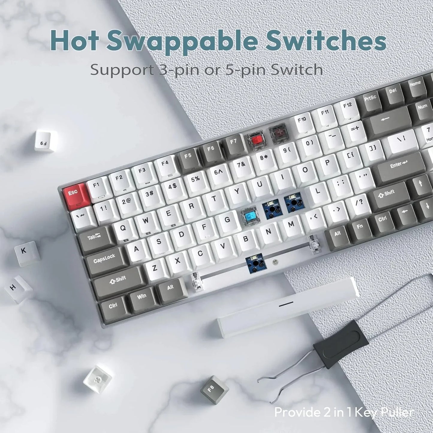 Mechanical keyboard with hot swappable switches, keycap puller tool, and removed white and gray keycaps on marble surface