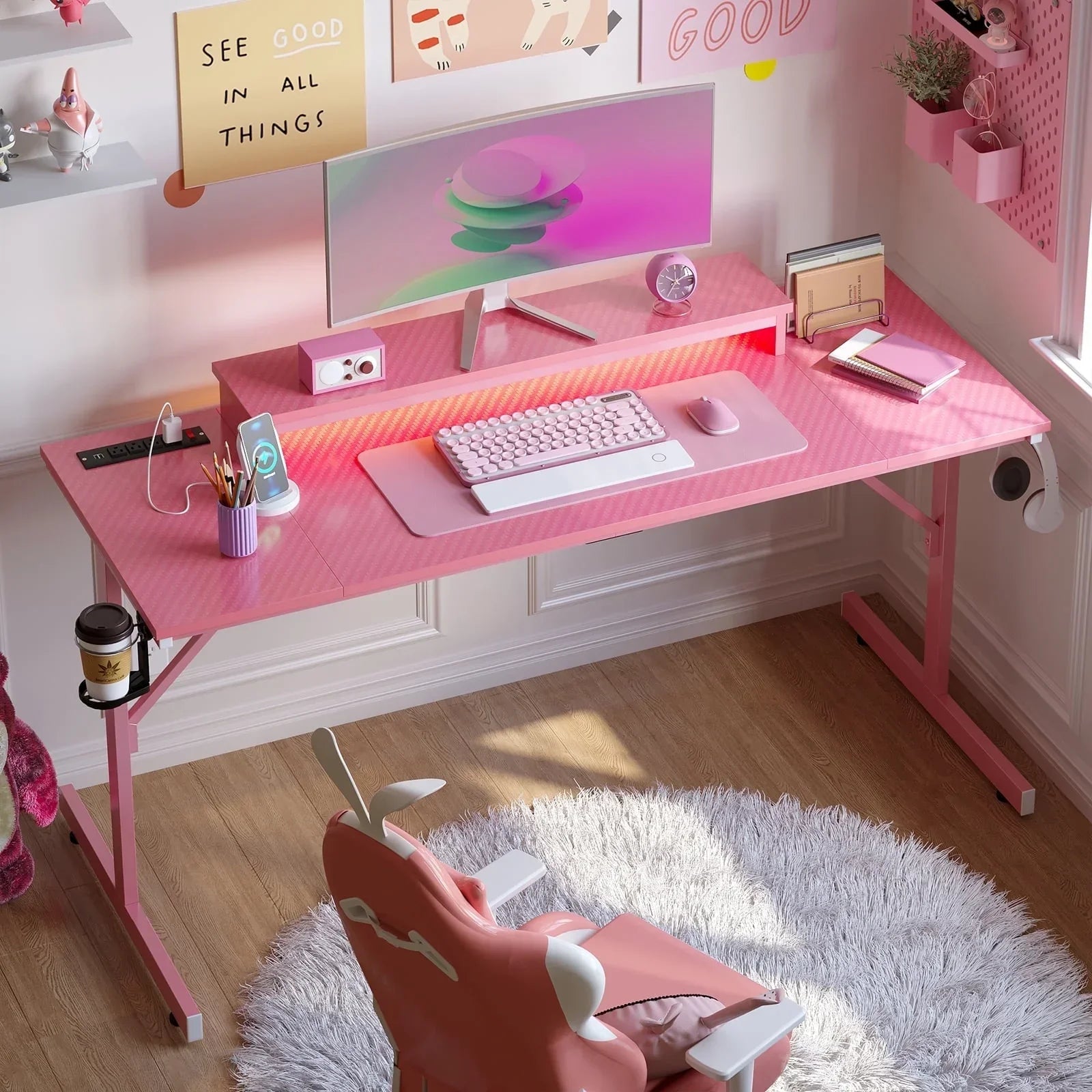 Pink gaming desk setup with curved monitor, mechanical keyboard, mouse, and ergonomic chair on white rug