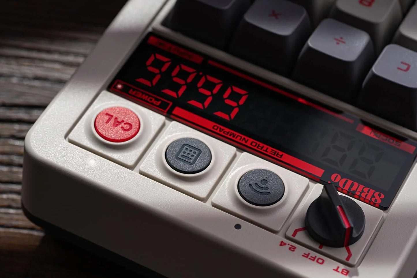 Close-up of a retro mechanical numpad keyboard with red digital display and calculator buttons.