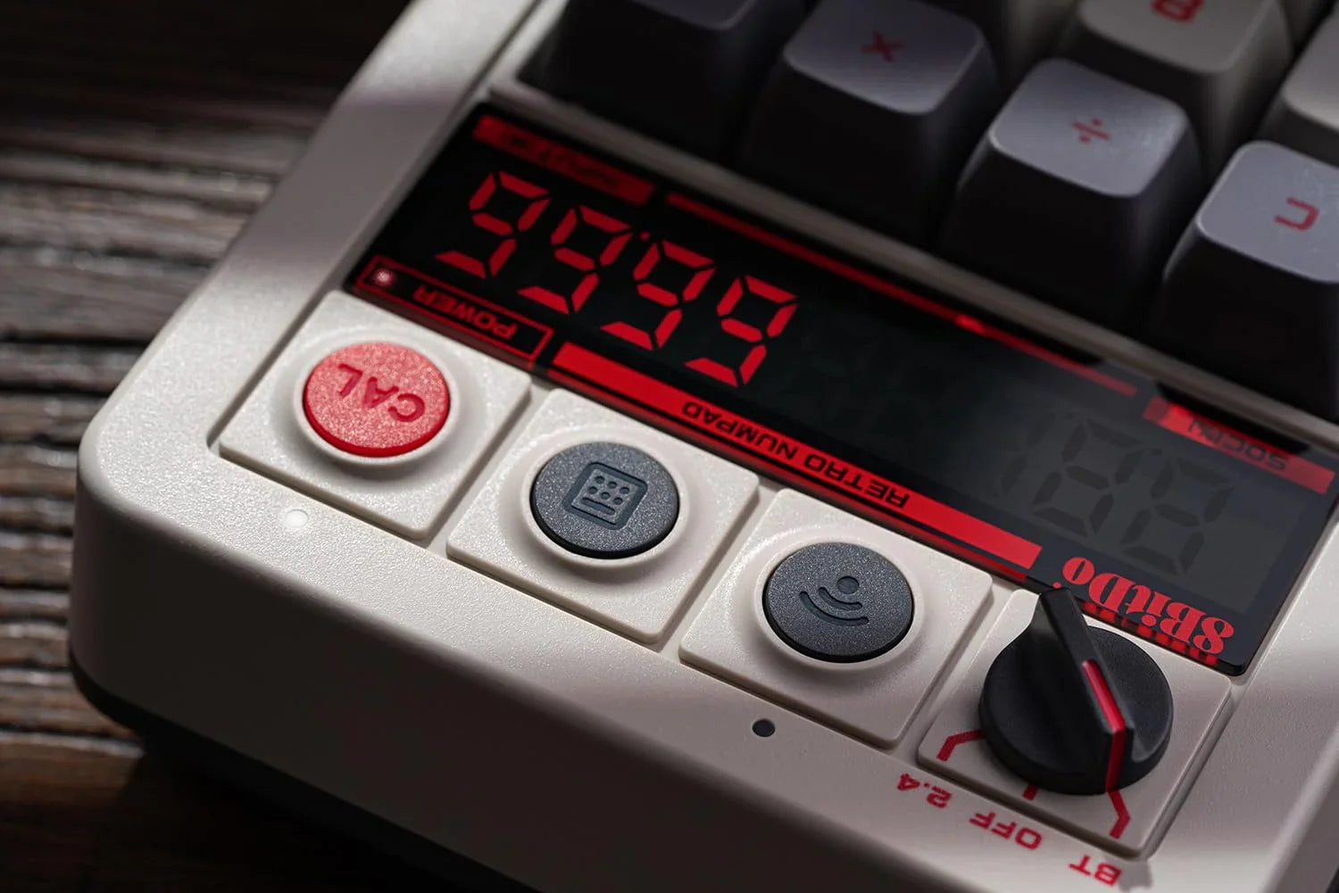 Close-up of a retro mechanical numpad keyboard with red digital display and calculator buttons.