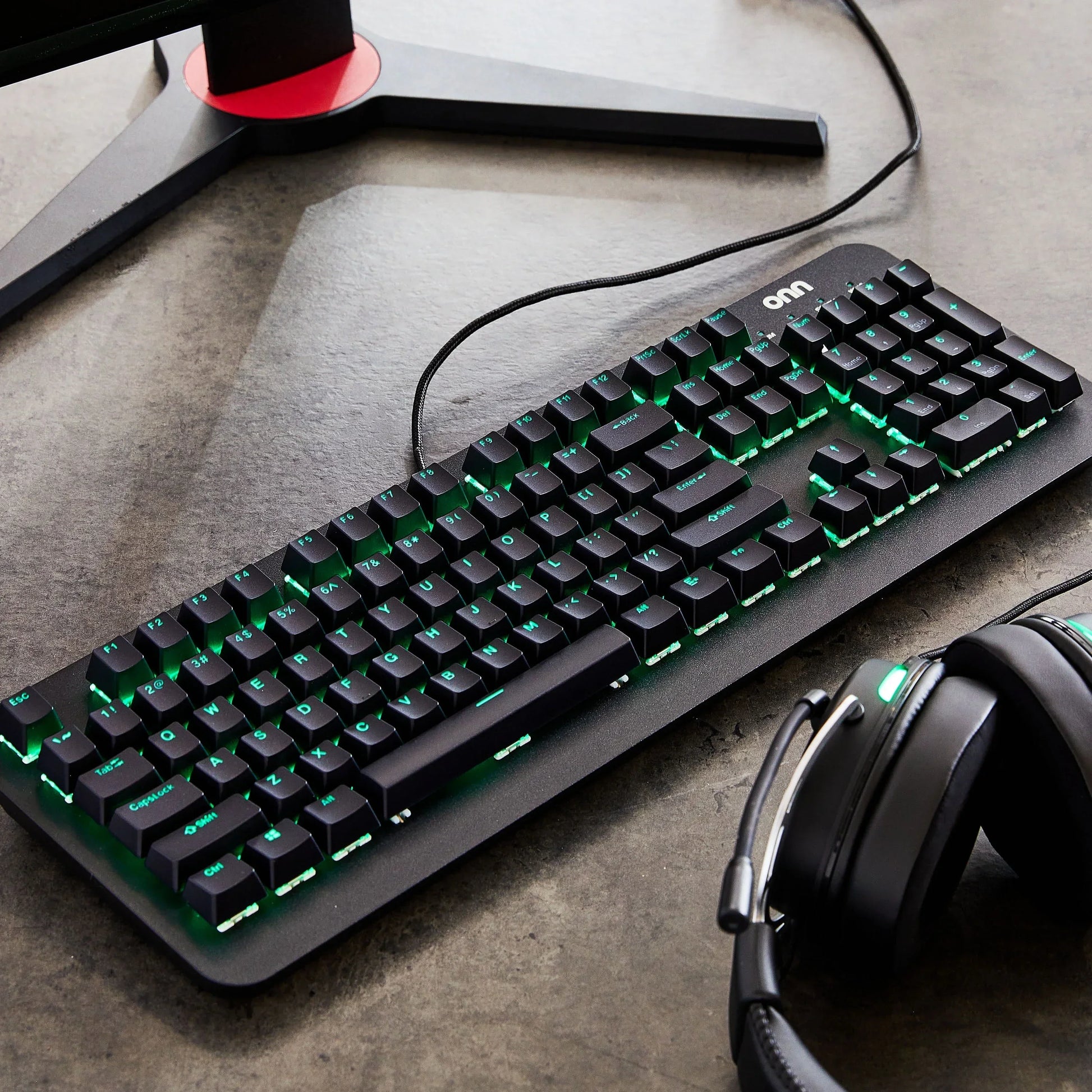 RGB gaming keyboard and headset on desk with monitor stand, Byte Style modern gaming gear