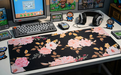 Floral gaming desk mat with pink roses on a desk, retro keyboard, mouse, and pixel art decor