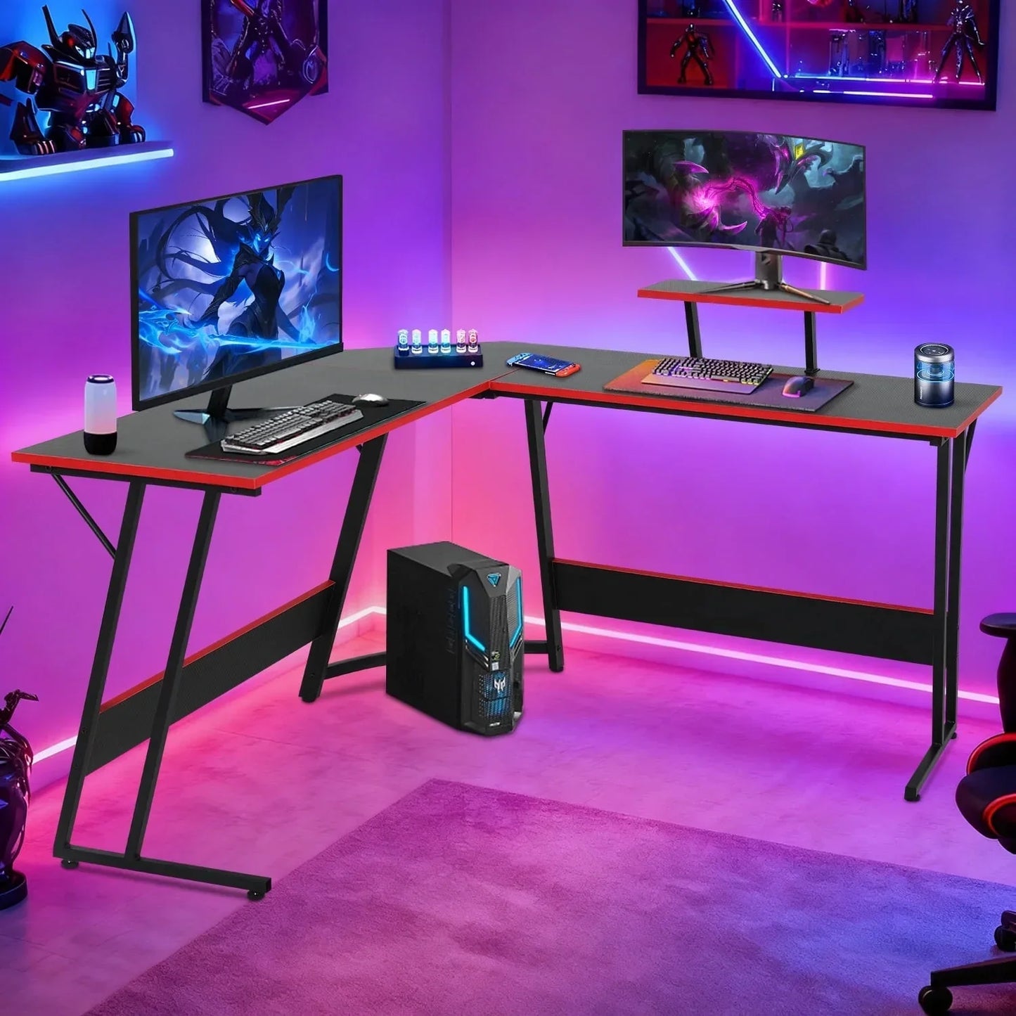 Modern L-shaped black and red gaming desk setup with dual monitors, RGB lighting, desktop PC, gaming keyboard, mouse, and gaming accessories