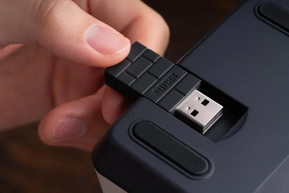 Hand inserting a retro 8-bit style USB dongle into a gaming device