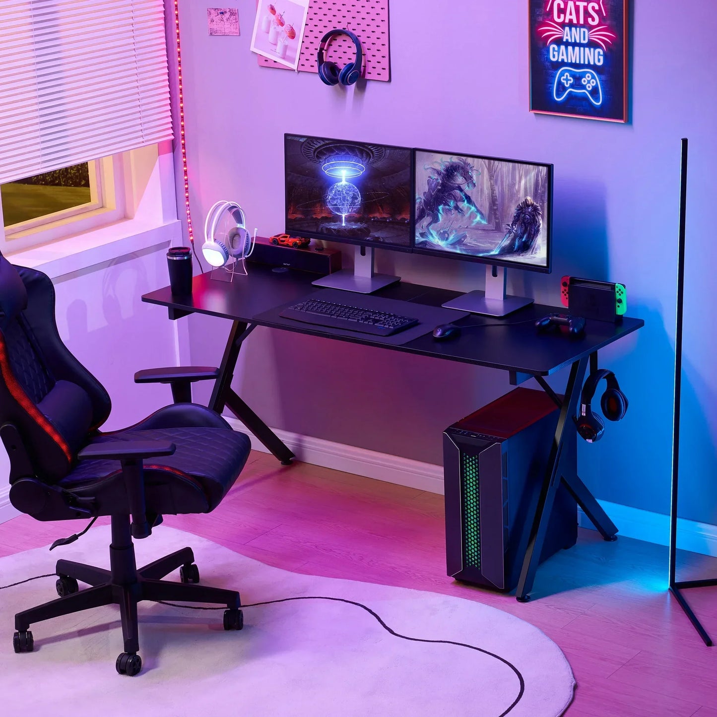 Modern gaming setup with dual monitors, gaming PC, black desk, ergonomic chair, colorful LED lighting