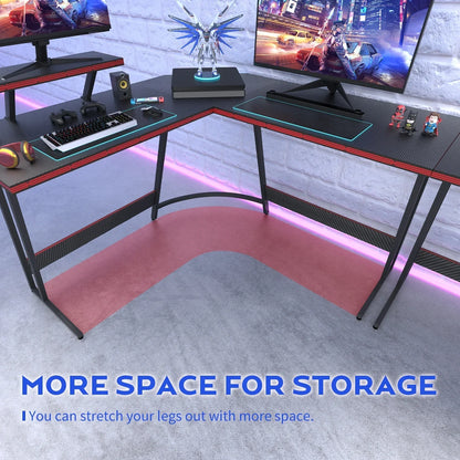 Corner gaming desk with RGB lighting, dual monitors, keyboard, controllers, and superhero figurines