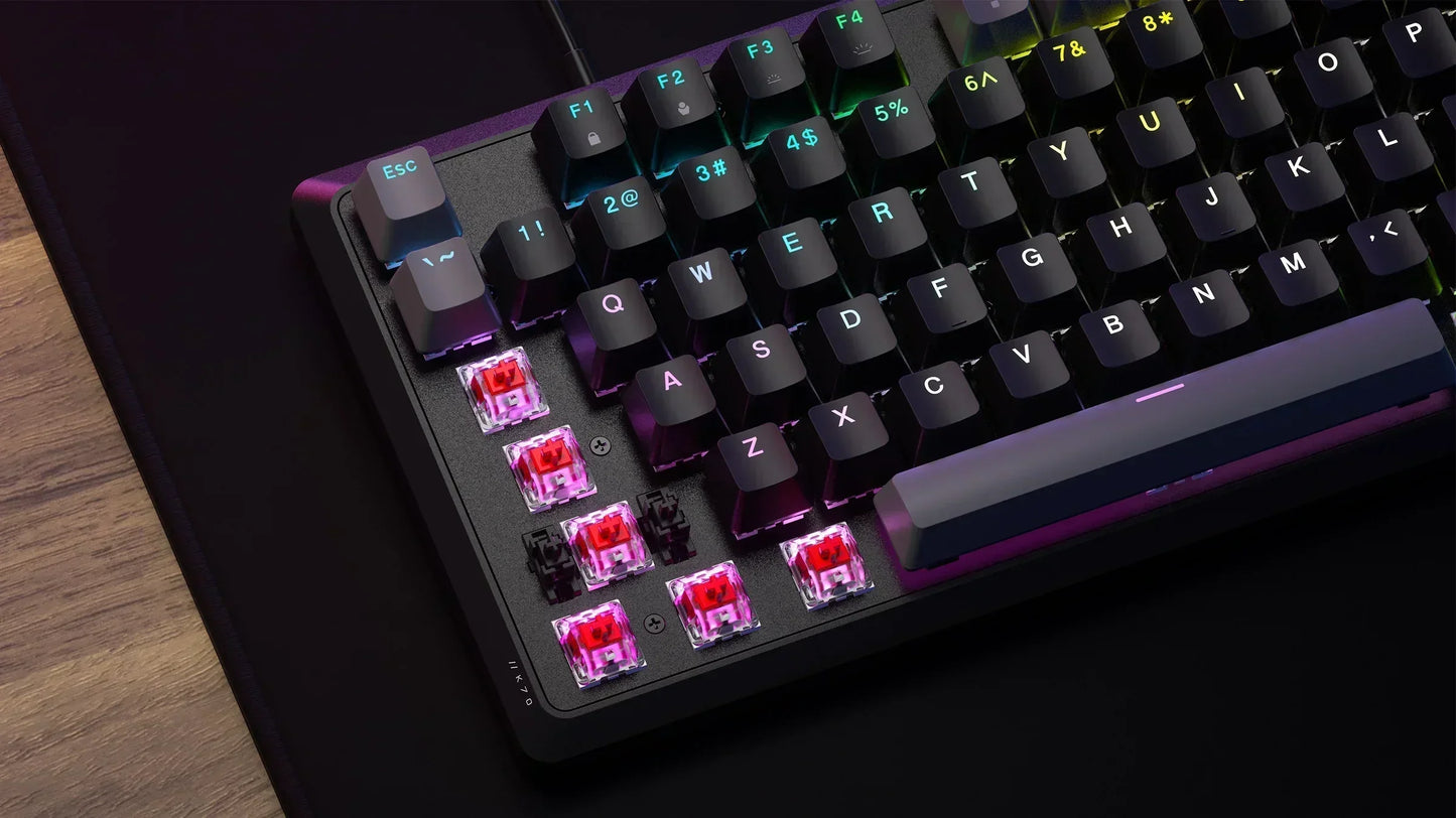 RGB mechanical gaming keyboard with exposed red switches and black keycaps on desk