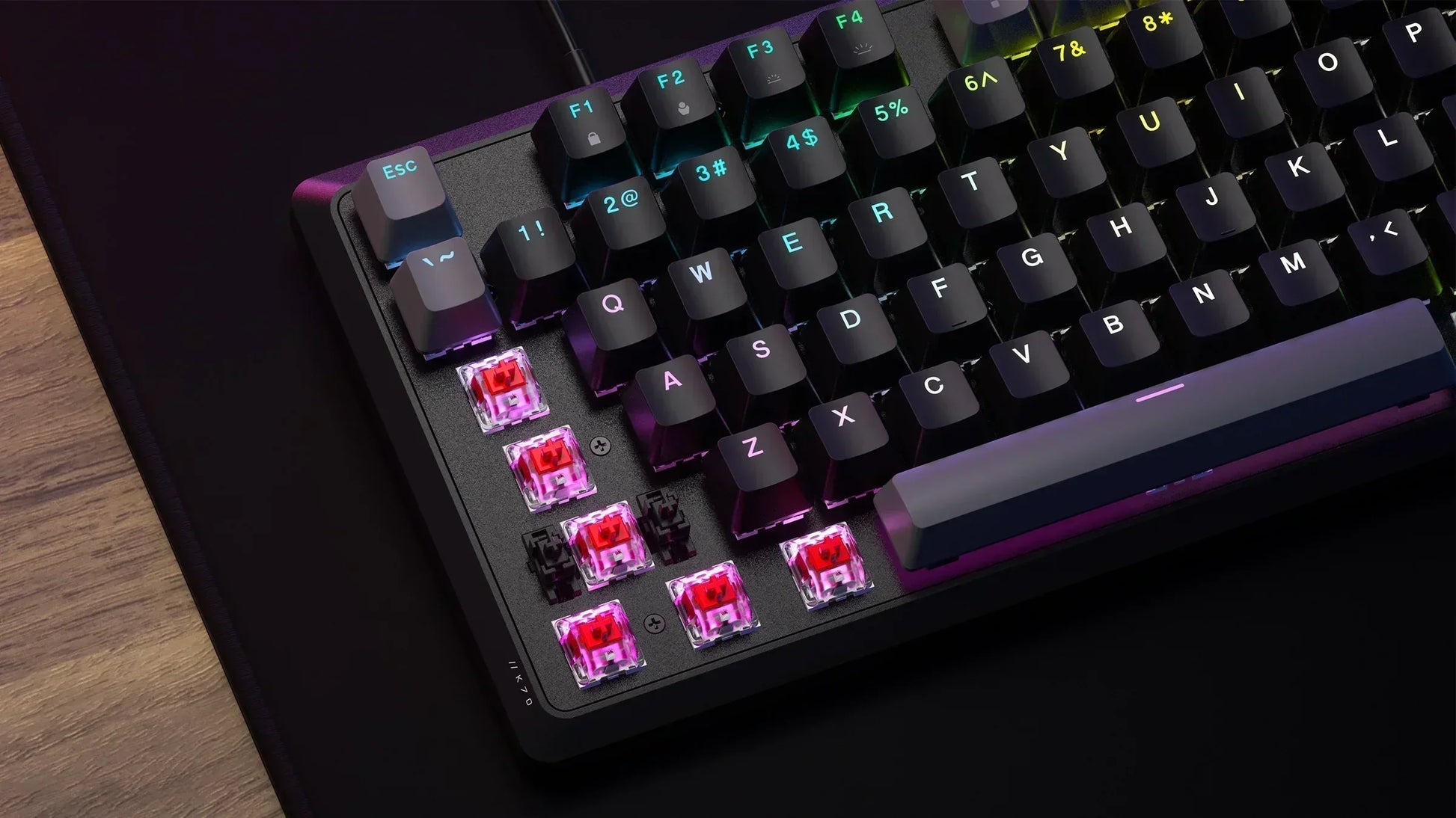 RGB mechanical gaming keyboard with exposed red switches and black keycaps on desk