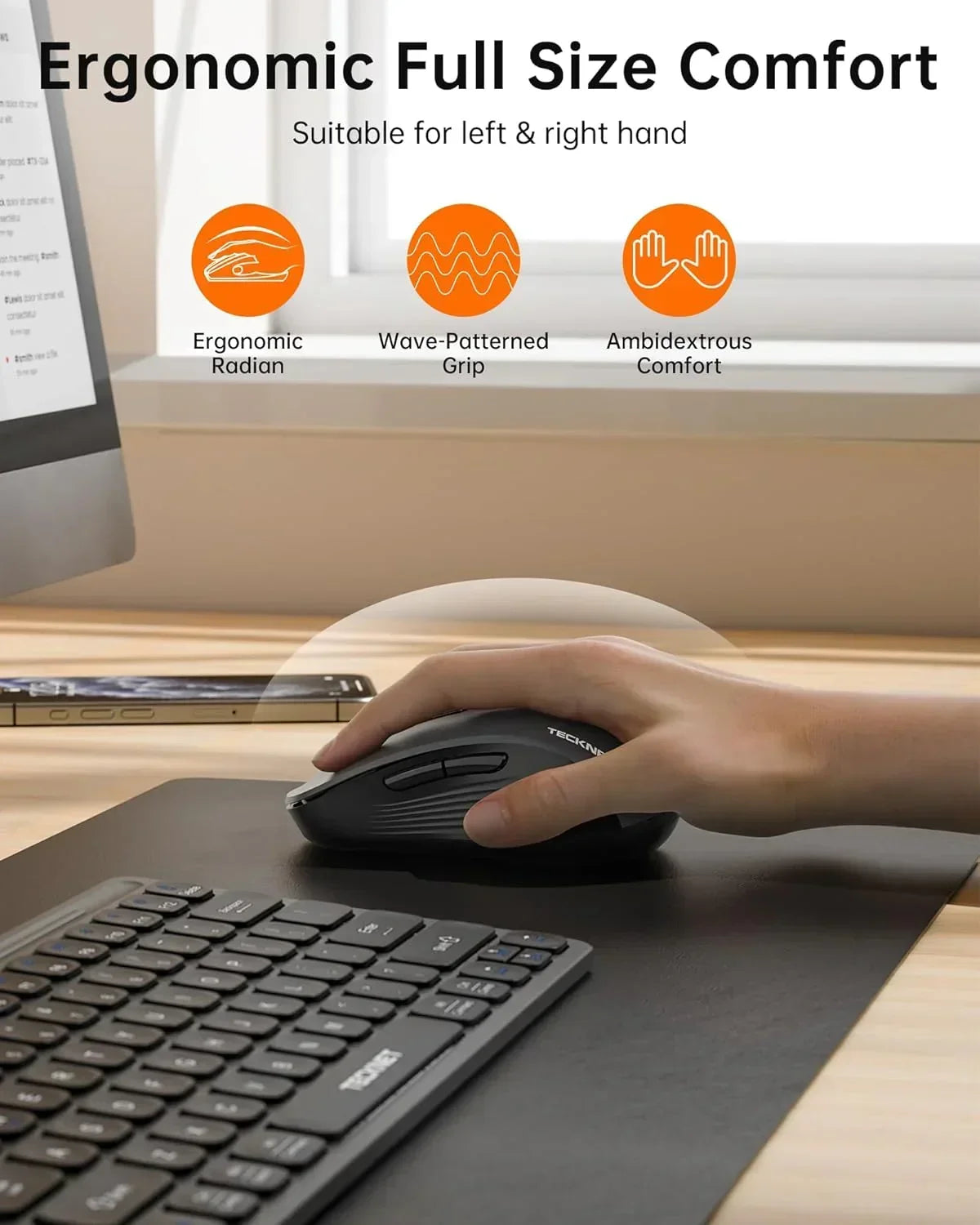 Hand using ergonomic wireless mouse with side buttons beside keyboard on desk, office setup