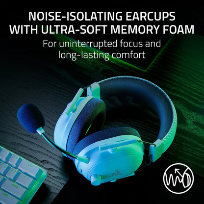White Razer gaming headset with noise-isolating earcups and ultra-soft memory foam on black desk near keyboard
