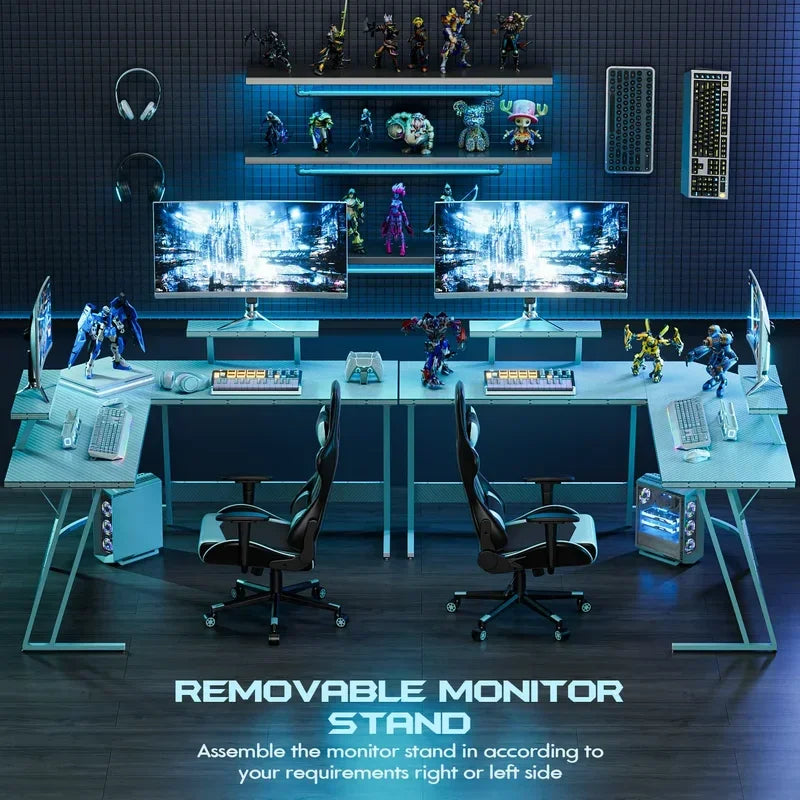 Modern dual gaming desk setup with removable monitor stands, RGB mechanical keyboards, gaming chairs, and action figures