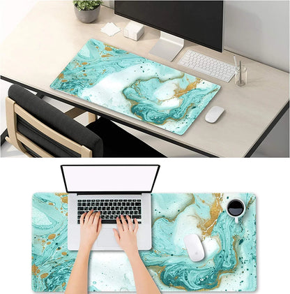 Modern desk setup with white keyboard, mouse, and monitor on teal and gold marble gaming desk mat