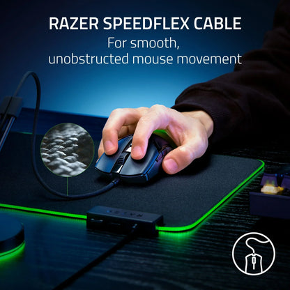 Hand using Razer wired gaming mouse with Speedflex cable on a black RGB mouse pad