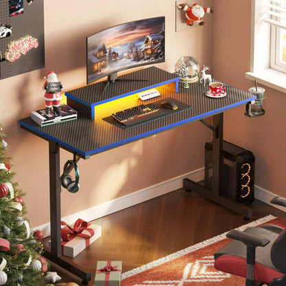 Gaming desk setup with carbon fiber surface, curved monitor, RGB lighting, decorated for Christmas with Santa and gifts