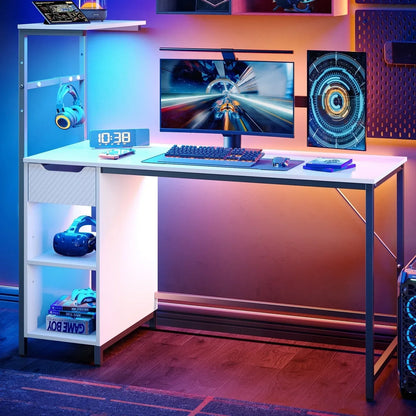 Modern white gaming desk setup with curved monitor, RGB backlighting, VR headset, headphones, keyboard, and game boxes