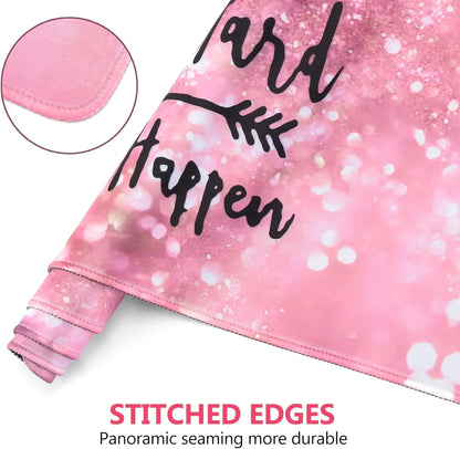 Pink gaming mouse pad with stitched edges and black motivational text on bokeh background