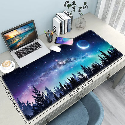 Spacious desk with galaxy night sky mouse pad, laptop, smartphone, books, and cup of coffee