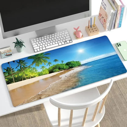 Desk setup with an ocean beach-themed extended mouse pad, white keyboard, monitor, and smartphone