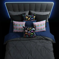 Modern bed with dark gray headboard, blue and gray bedding, and colorful gaming and cupcake themed pillows