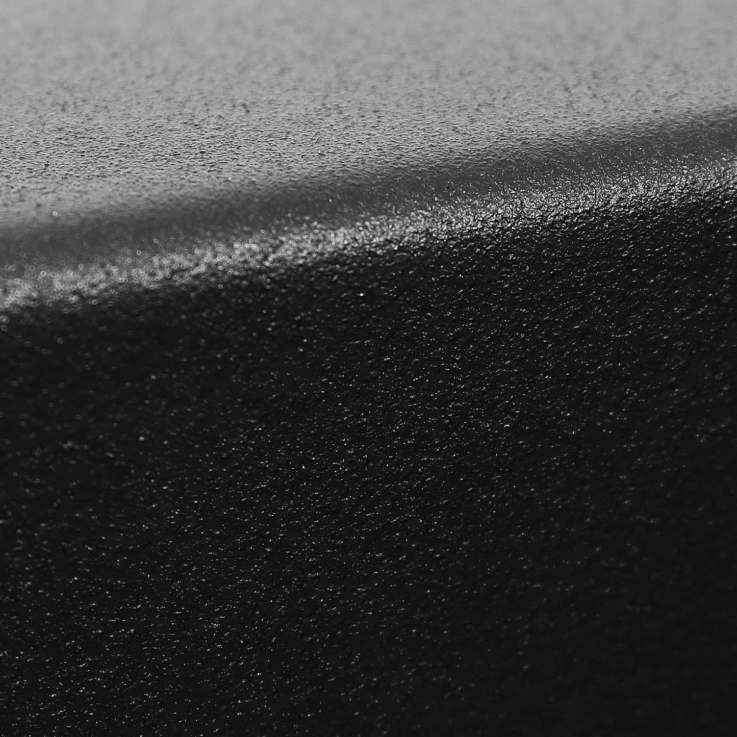 Close-up of textured black anti-slip surface with curved edge