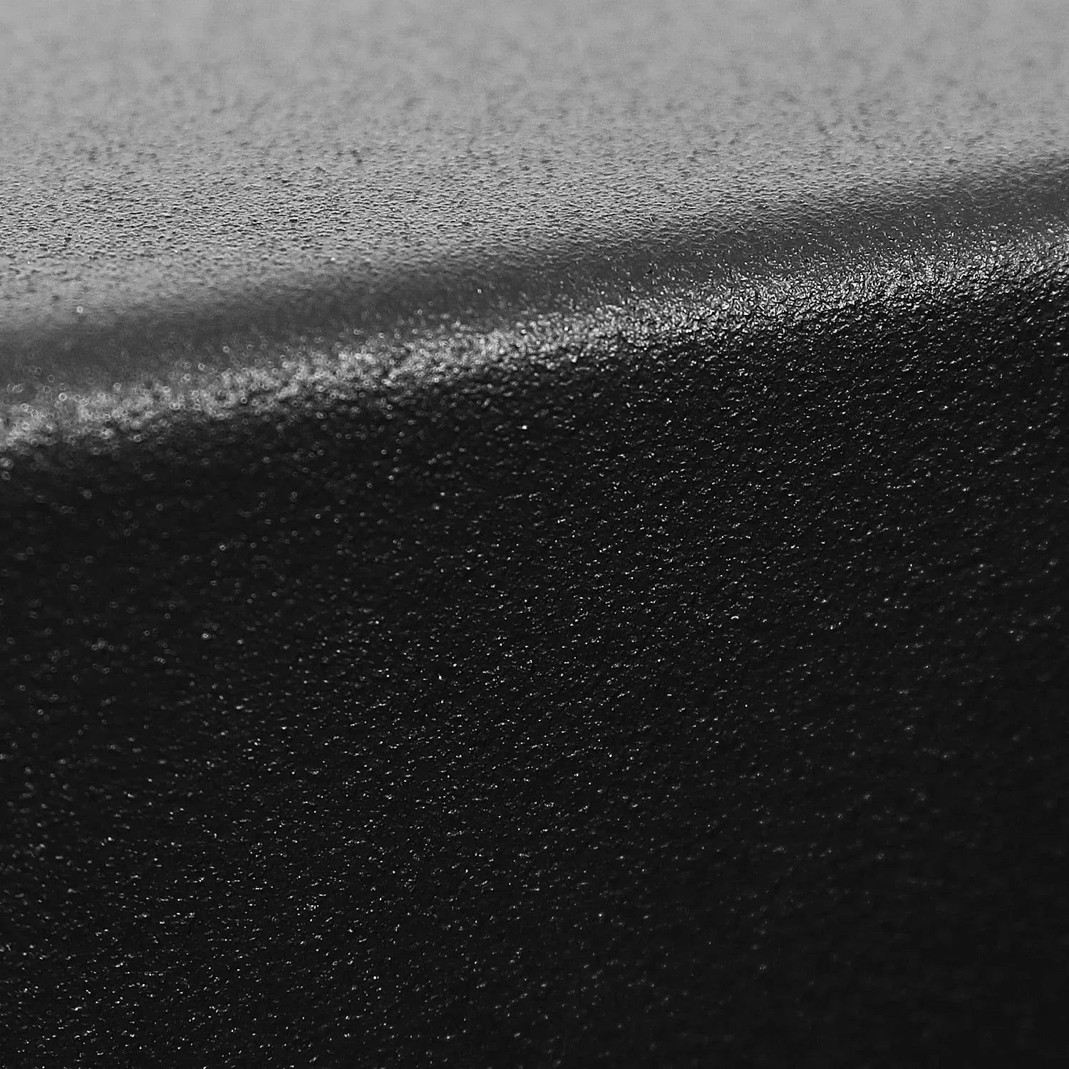 Close-up of textured black anti-slip surface with curved edge