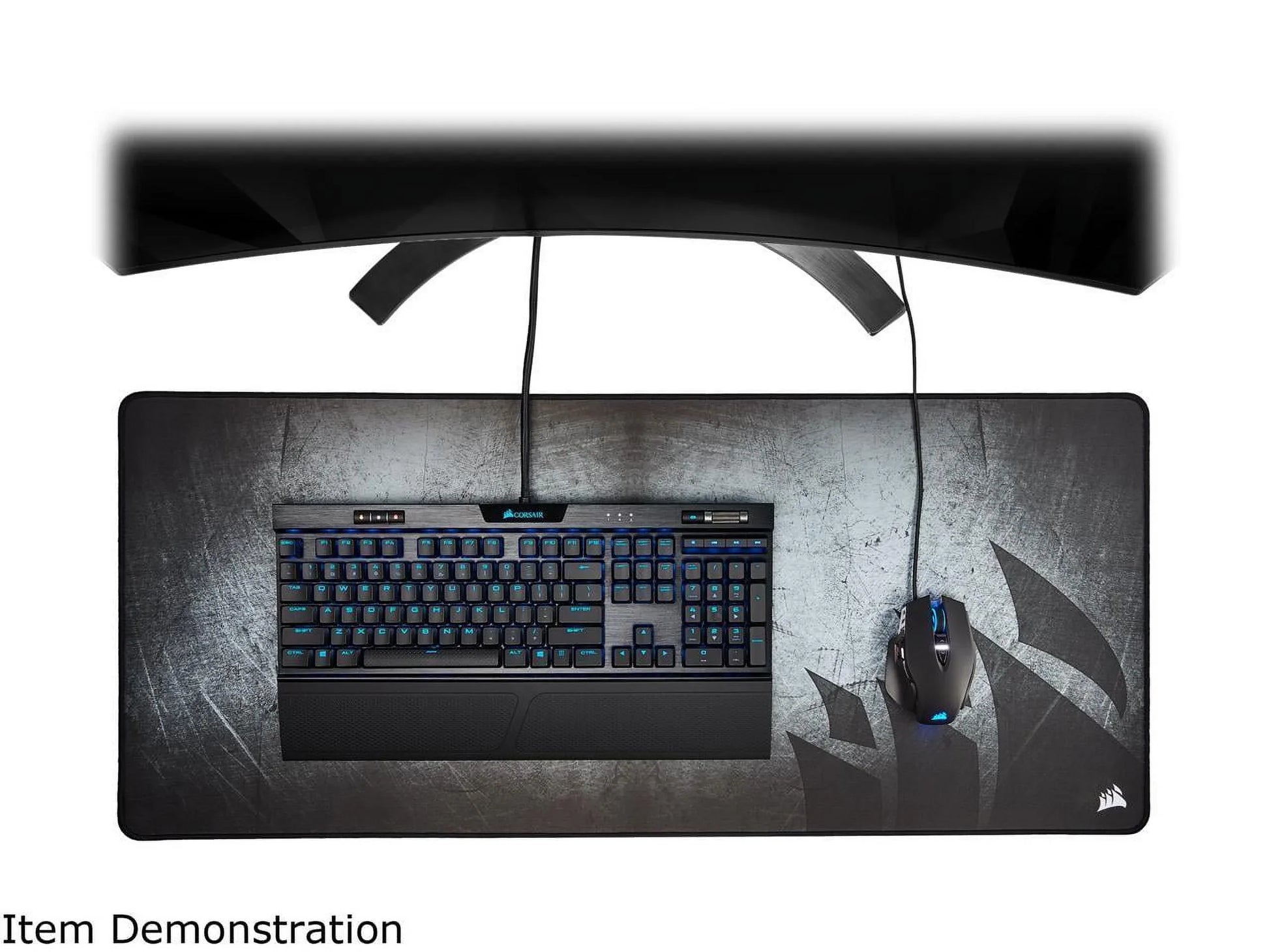 Gaming setup with Corsair mechanical keyboard and RGB mouse on large gaming mousepad under curved monitor