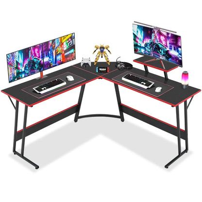 L-shaped black and red gaming desk with dual monitors, mechanical keyboards, mouse, headset, and gaming accessories