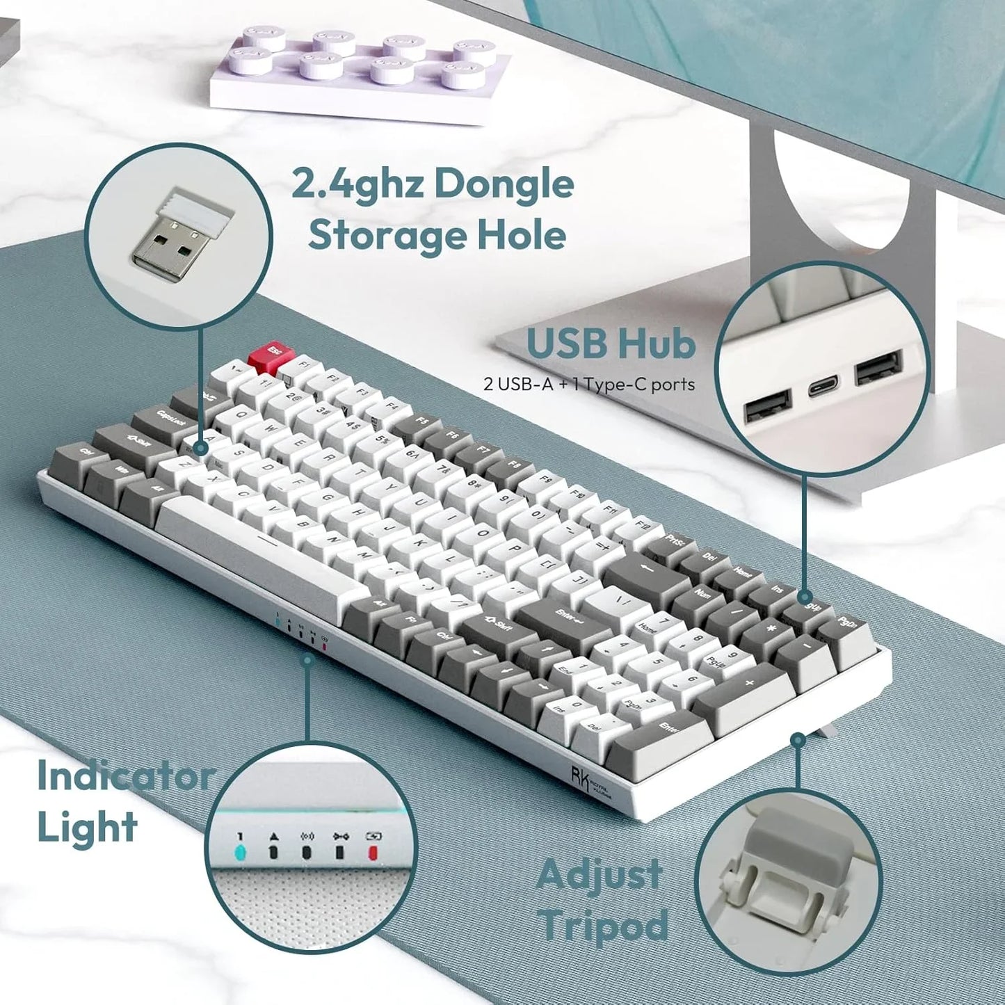 RK mechanical keyboard with white and gray retro keys on a blue mat, showing 2.4 GHz dongle storage, USB hub, indicator lights, and adjustable tripod