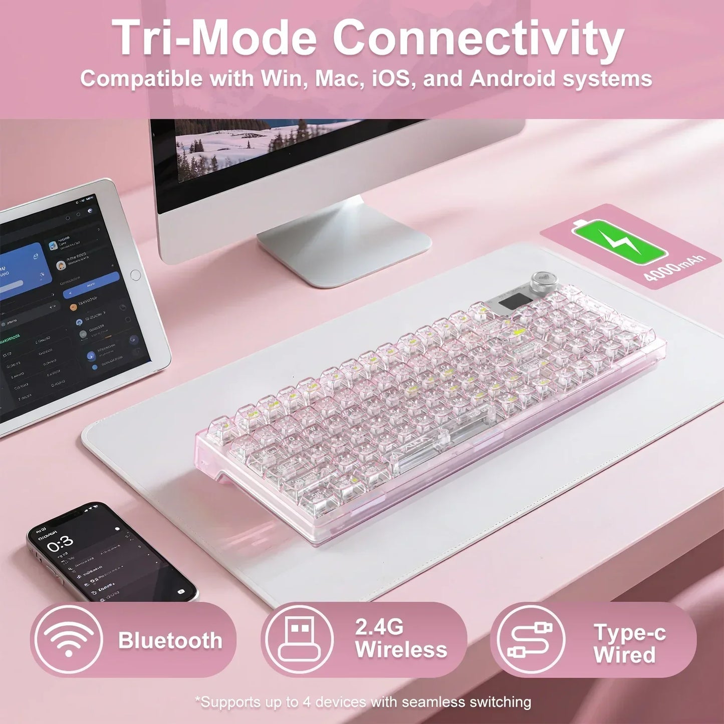 Pink transparent mechanical keyboard with tri-mode connectivity on a pastel desk setup with PC, tablet, and phone.
