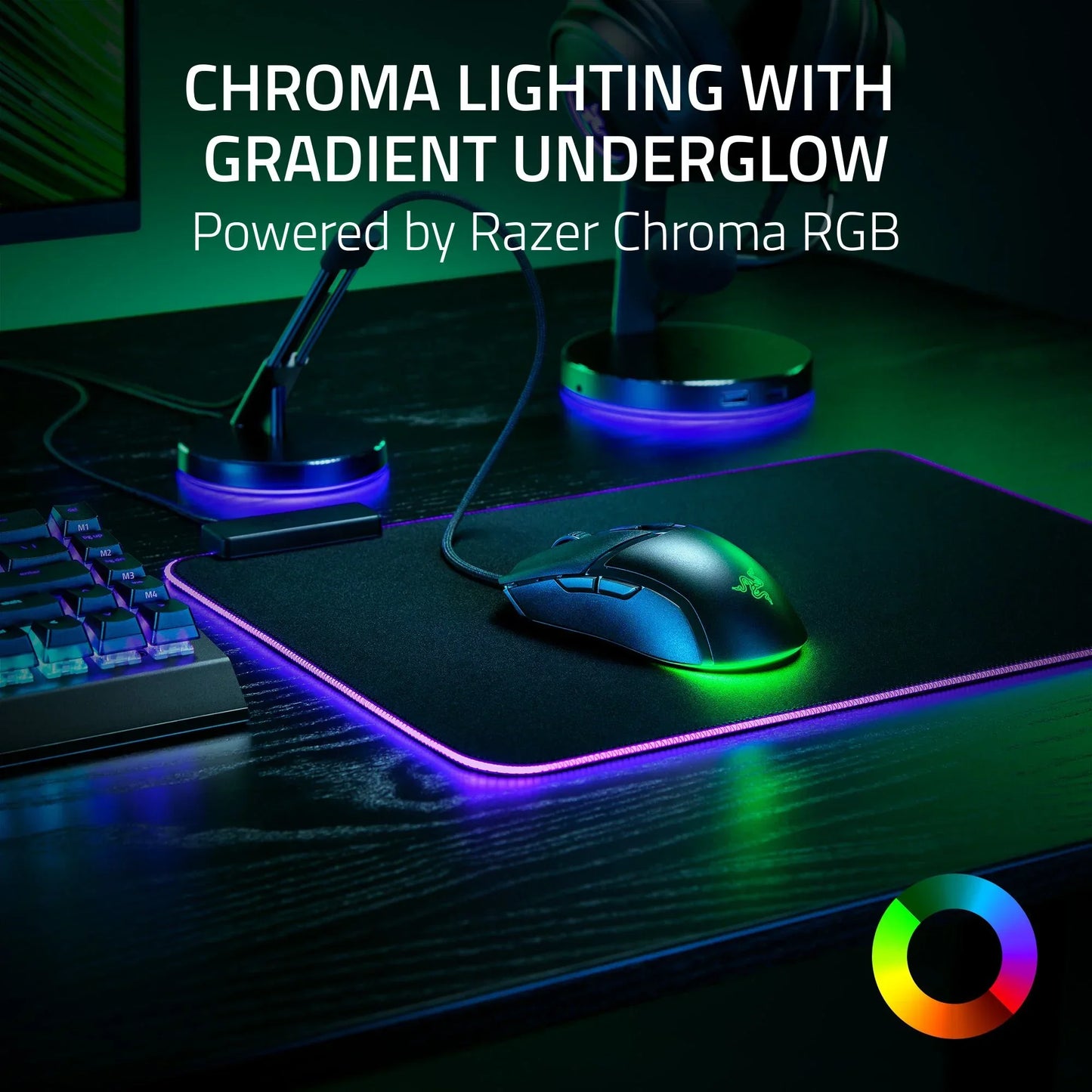 Gaming mouse on RGB-lit mouse pad with glowing keyboard and mic stands on black desk