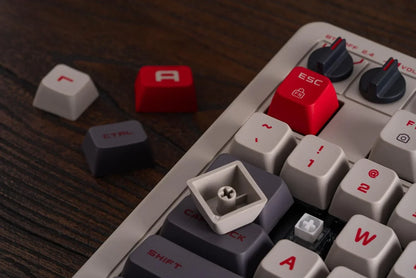 Close-up of retro gaming mechanical keyboard with red and gray keycaps on wooden desk