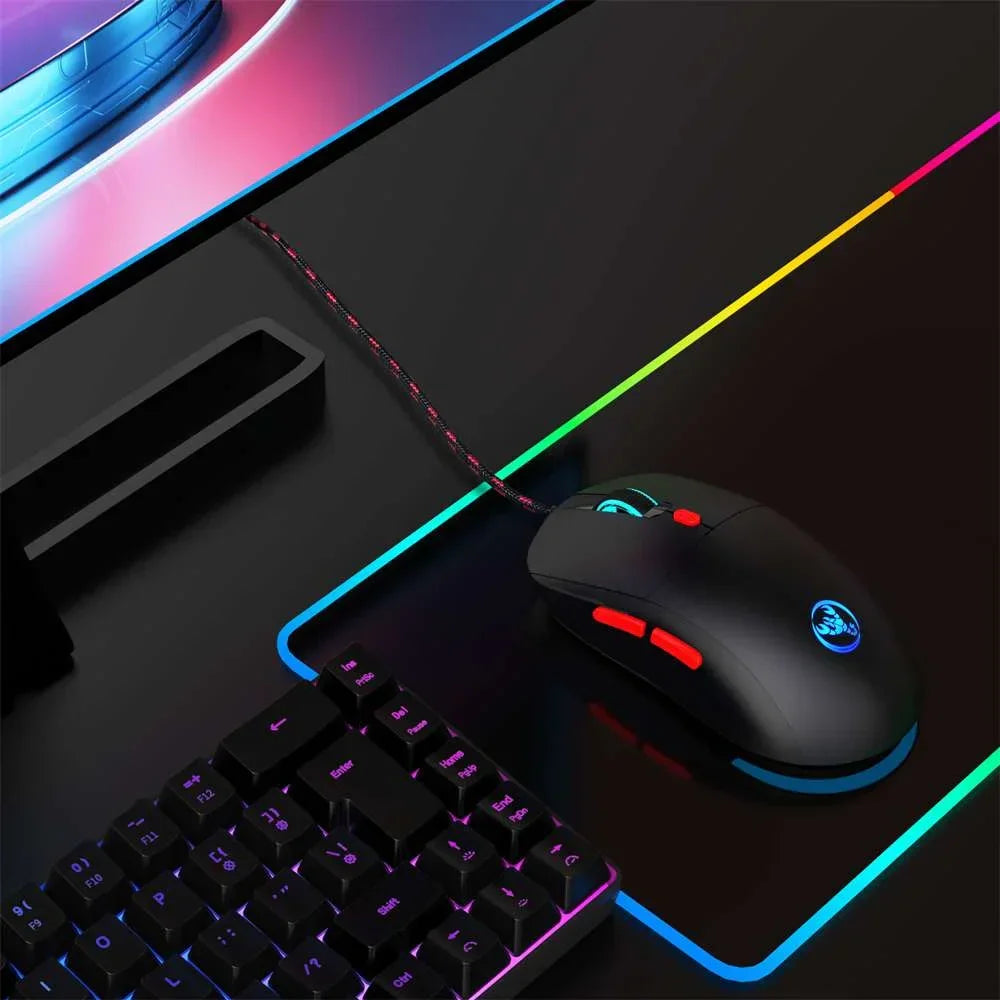 RGB gaming mouse and mechanical keyboard on black mouse pad with colorful LED edges