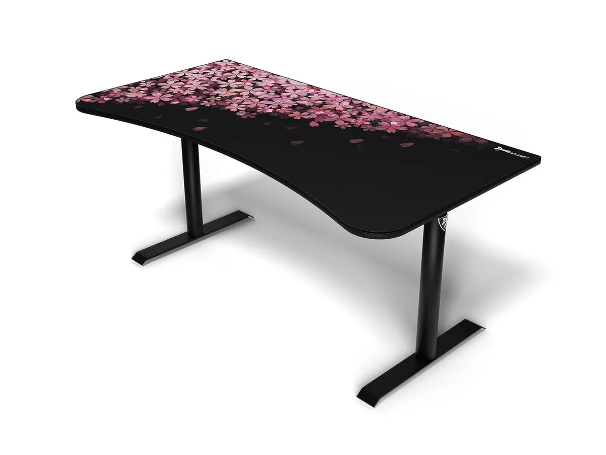 Black ergonomic gaming desk with pink cherry blossom petals design on top and sturdy black metal legs