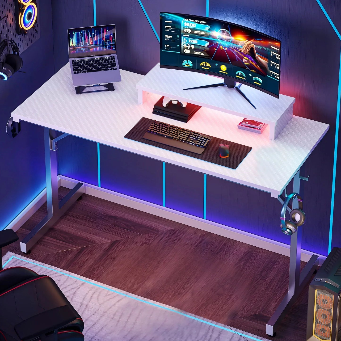 Modern gaming desk setup with curved monitor, laptop, keyboard, mouse, headphones, LED lighting, and wood flooring