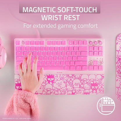 Pink Razer gaming keyboard with magnetic soft-touch wrist rest, Hello Kitty design, desktop setup.