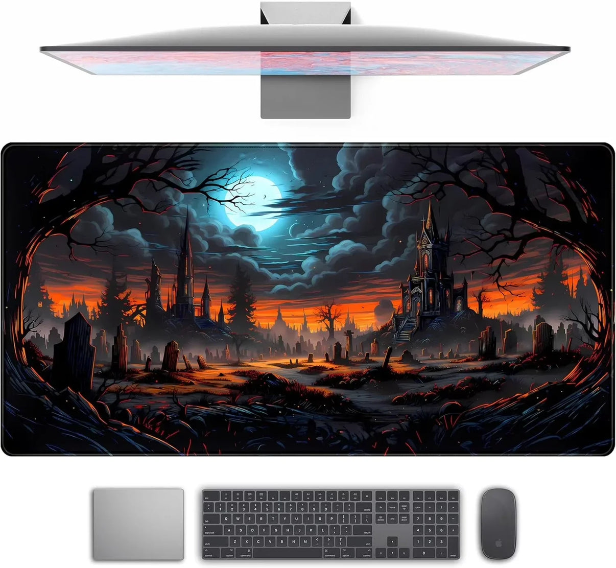 Gaming desk setup with a widescreen mousepad featuring a spooky graveyard scene under a full moon and dark clouds