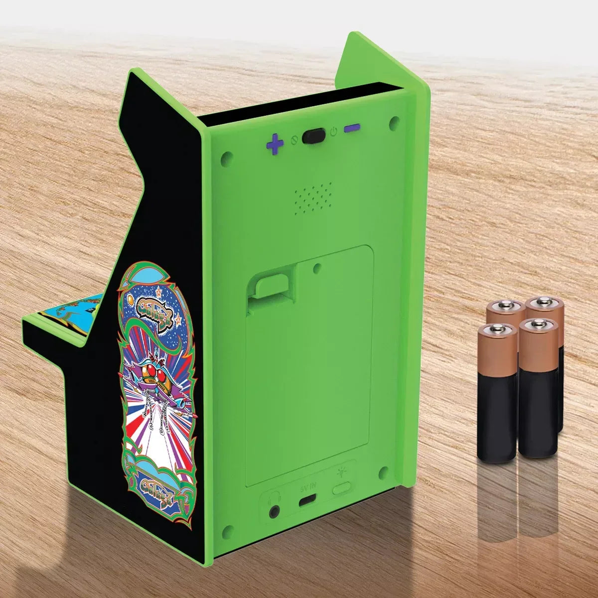 Back of green mini retro arcade cabinet with batteries on wood surface, Byte Style gaming gear