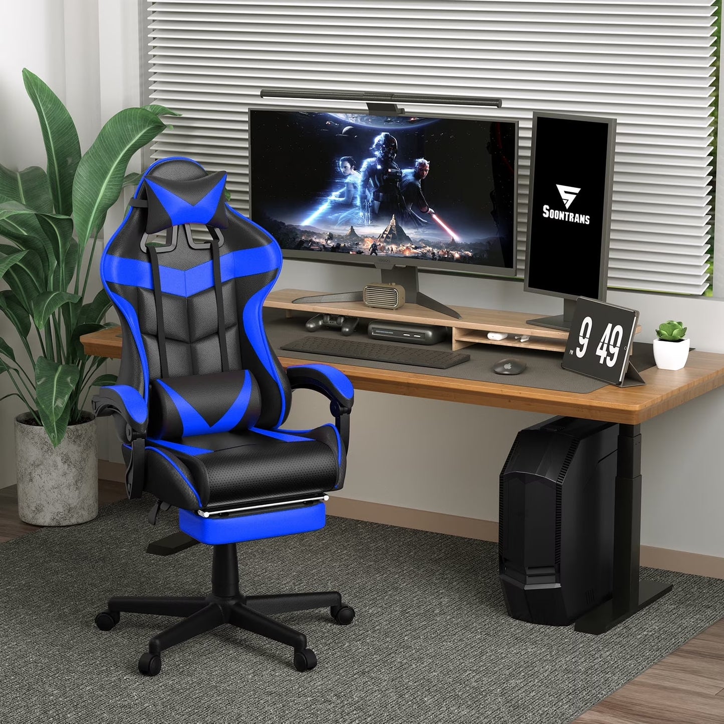 Blue and black gaming chair with footrest at a desk setup featuring dual monitors and PC