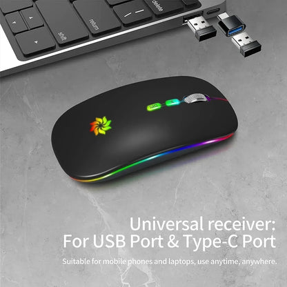 Wireless RGB gaming mouse with USB and Type-C receiver next to a laptop on a gray surface