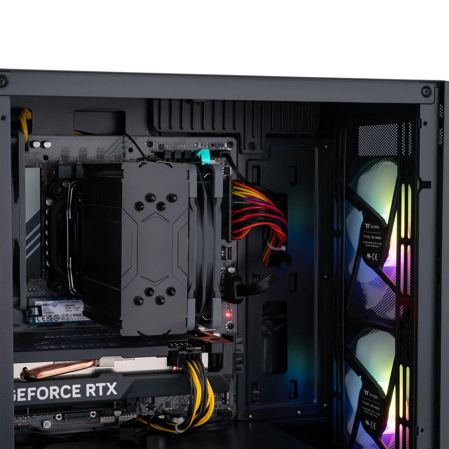 Inside view of a gaming PC case showing GeForce RTX graphics card, CPU cooler, and RGB-lit cooling fans