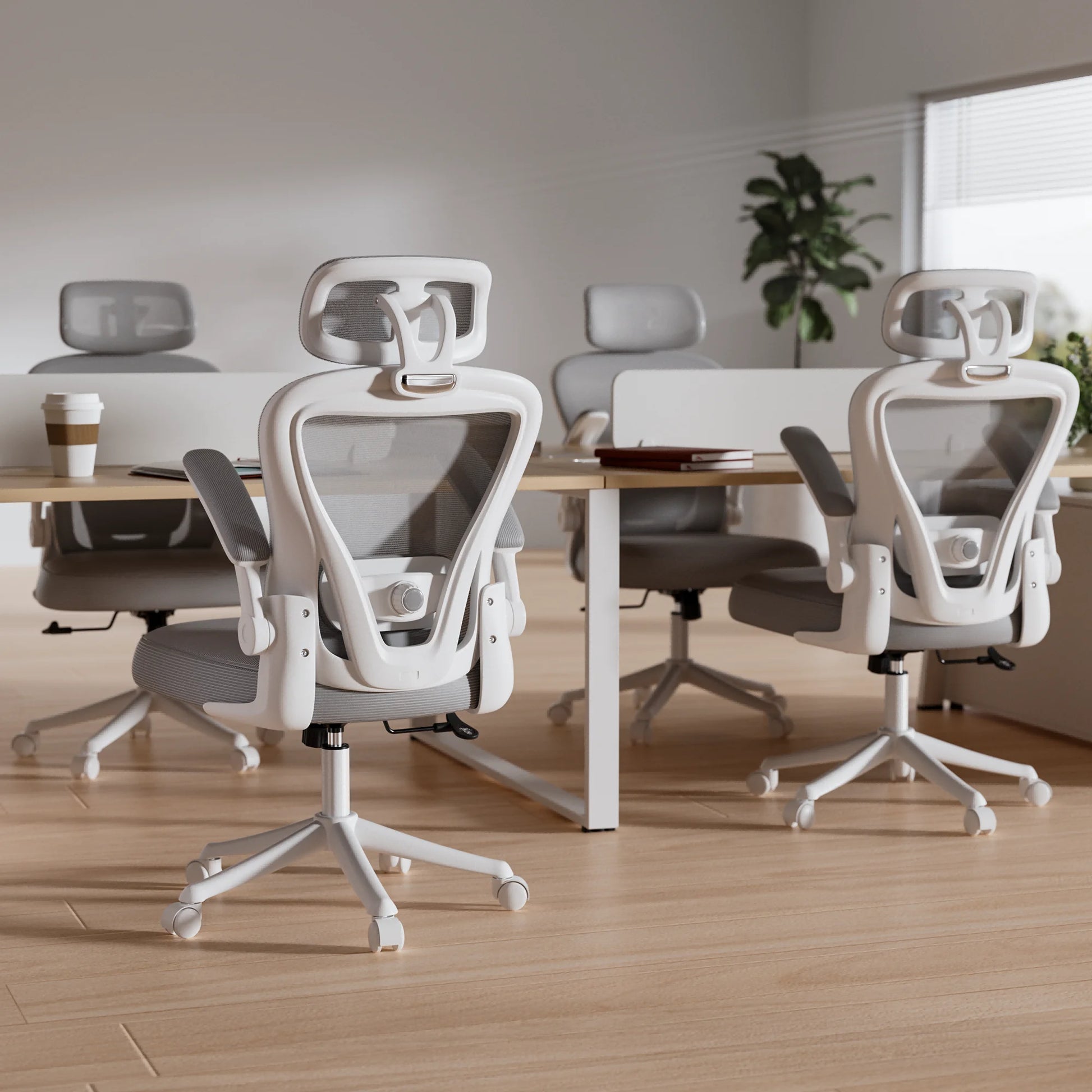 White ergonomic office chairs with mesh backrests at modern desks in bright workspace