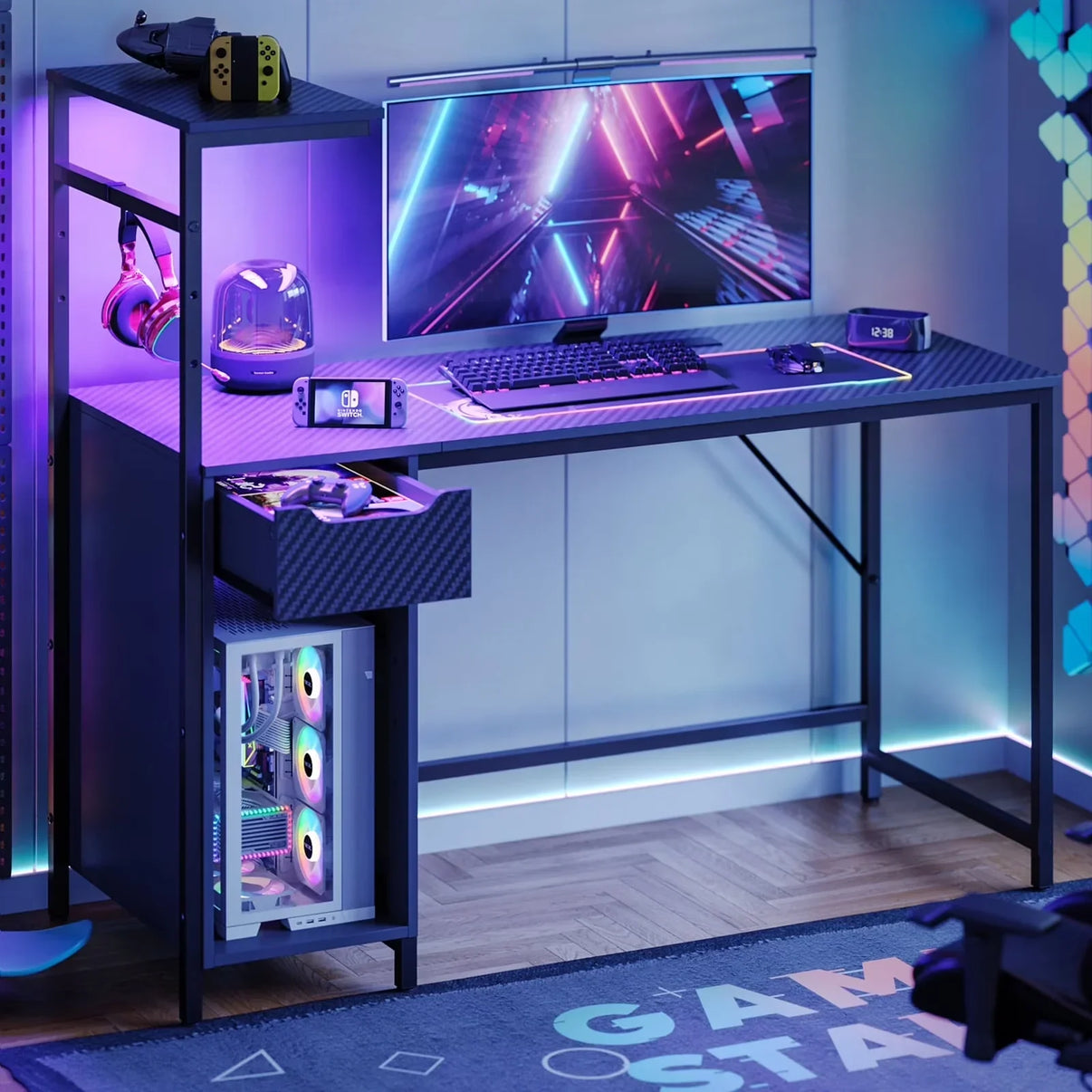 Modern gaming setup with RGB-lit desktop PC, wide monitor, mechanical keyboard, Nintendo Switch, and gaming headphones